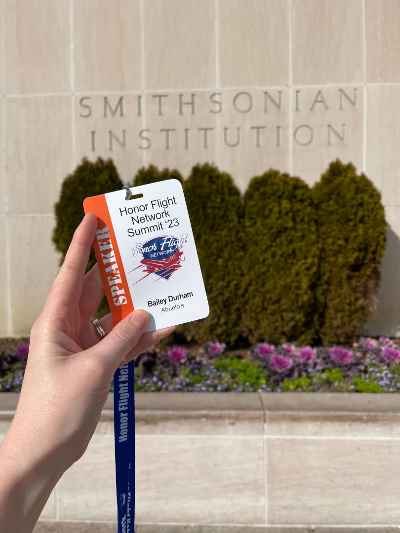 Hand holding Honor Flight Network Summit card and lanyard